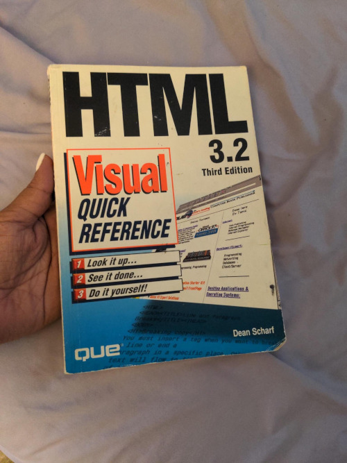 My hand holding the book “HTML 3.2, Visual quick reference, Third Edition.”